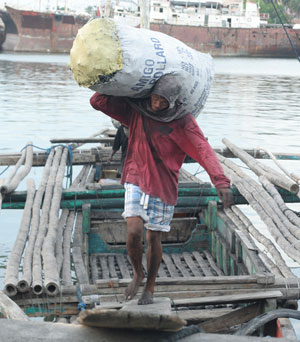 A man unloads a sack of charcoal coming from Guimaras at the Muelle Loney wharf in Iloilo City.