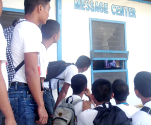 PNP applicants flock outside the Message Center of Police Regional Office 6 to watch through the small window the NBA finals between L.A. Lakers and Boston Celtics.