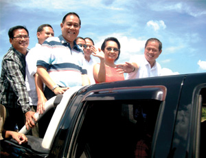 Pres. Gloria Macapagal-Arroyo waves to the spectators during the inaugural drive-through for the new Tigum Bridge in Brgy. Tabucan, Cabatuan, Iloilo yesterday.