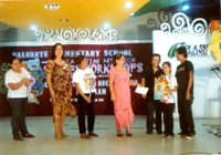 During the awarding of one of the winning poster making entries by Ma. Febe Acla. She's assisted by her father and congratulated by Louela Gregorio, Dr. Dominica Parcia, principal of BES; Medlyn Divinagracia, district supervisor; and Angelita Ragodo, asst. schools division superintendent.