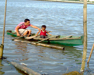 A father and son sail along the river in Brgy. San Juan, Molo district as Mayor Jed Patrick Mabilog orders the removal of illegal fishpens in Iloilo River by mid-September. 