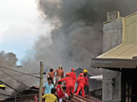 Firefighters climb the rooftops of houses in Brgy. Rizal Ibarra, City Proper to contain the blaze that hit the area Tuesday afternoon.