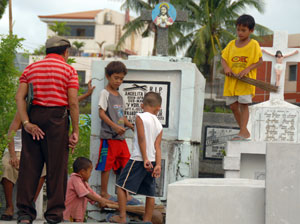 Children join the clean-up at a cemetery in Iloilo City