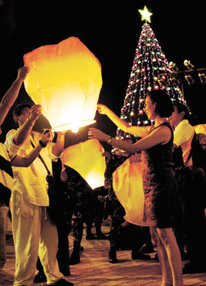 Guests release the flying peace lantern during the lighting of the 40-feet Christmas Tree